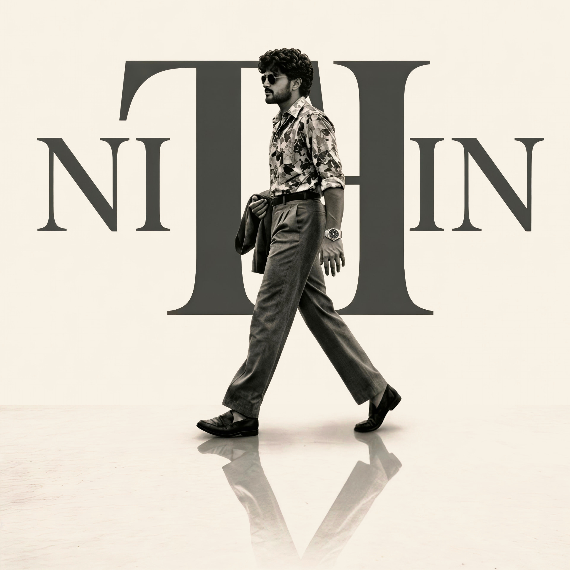 Nithin K walking in front of a large NITHIN wordmark
